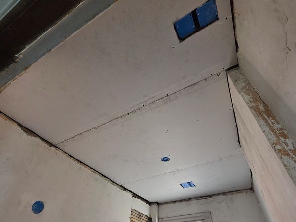 Ceiling with electrical box installations in an unfinished room.