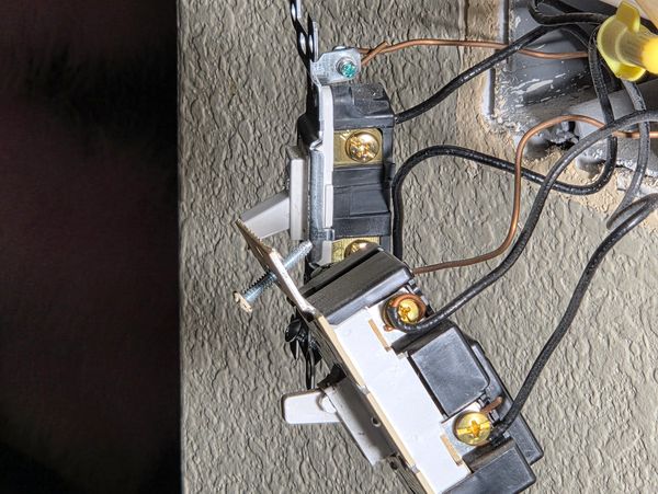 Two exposed electrical outlets with wiring visible on a textured wall.