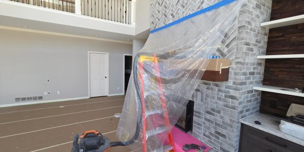 Room under renovation with protective coverings and ladder.