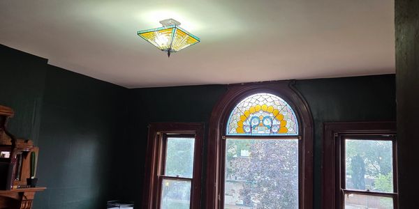 Room with stained glass windows and dark walls.