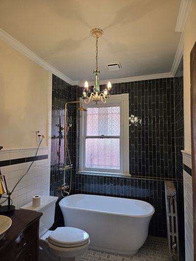 Vintage bathtub and chandelier in elegant bathroom.