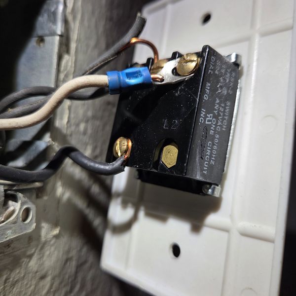 Close-up of an electrical switch with wires connected.