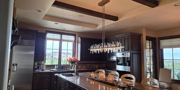 Modern kitchen with dark wood cabinets and large windows.