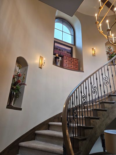 Curved staircase with elegant iron railing and soft lighting.