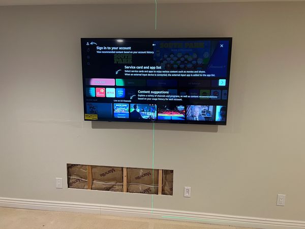 Wall-mounted TV with a rectangular cutout below.