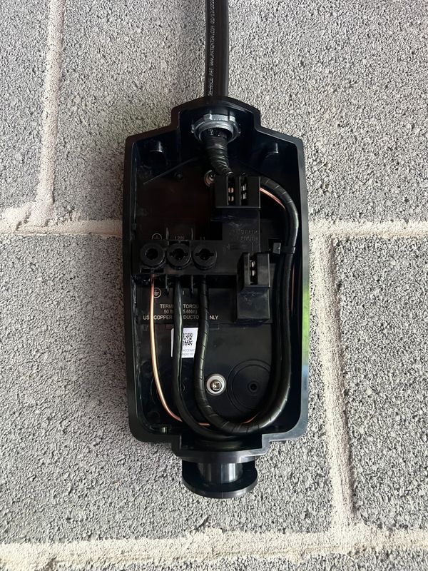Open electrical junction box with cables inside.