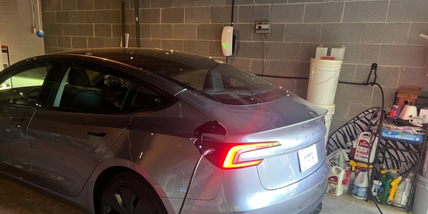 Tesla charging in a garage.