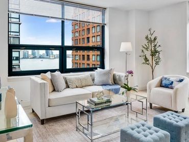 Photo of staged NYC living room with blue, silver and white accents.
