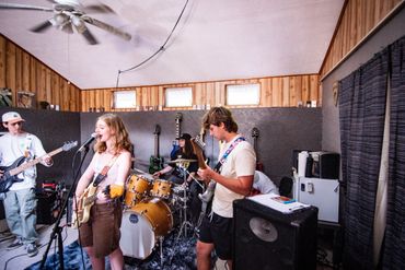 Young band rehearsing in a cozy wooden room with instruments.