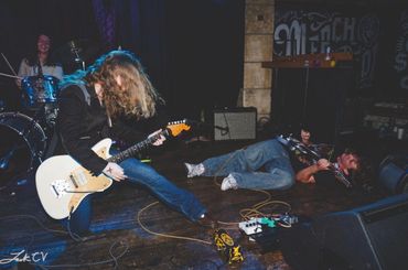Energetic rock band performance with guitarist and vocalist on stage.