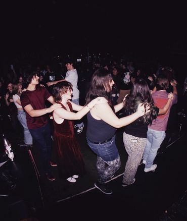 Group of people dancing in a conga line at a lively party.