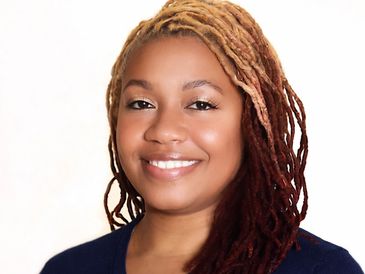 Smiling woman with braided hair and a warm expression.