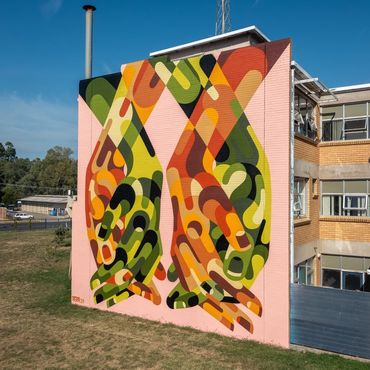 Colorful mural of abstract hands on a building wall.