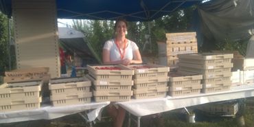 Farmer with crates of stone fruit.