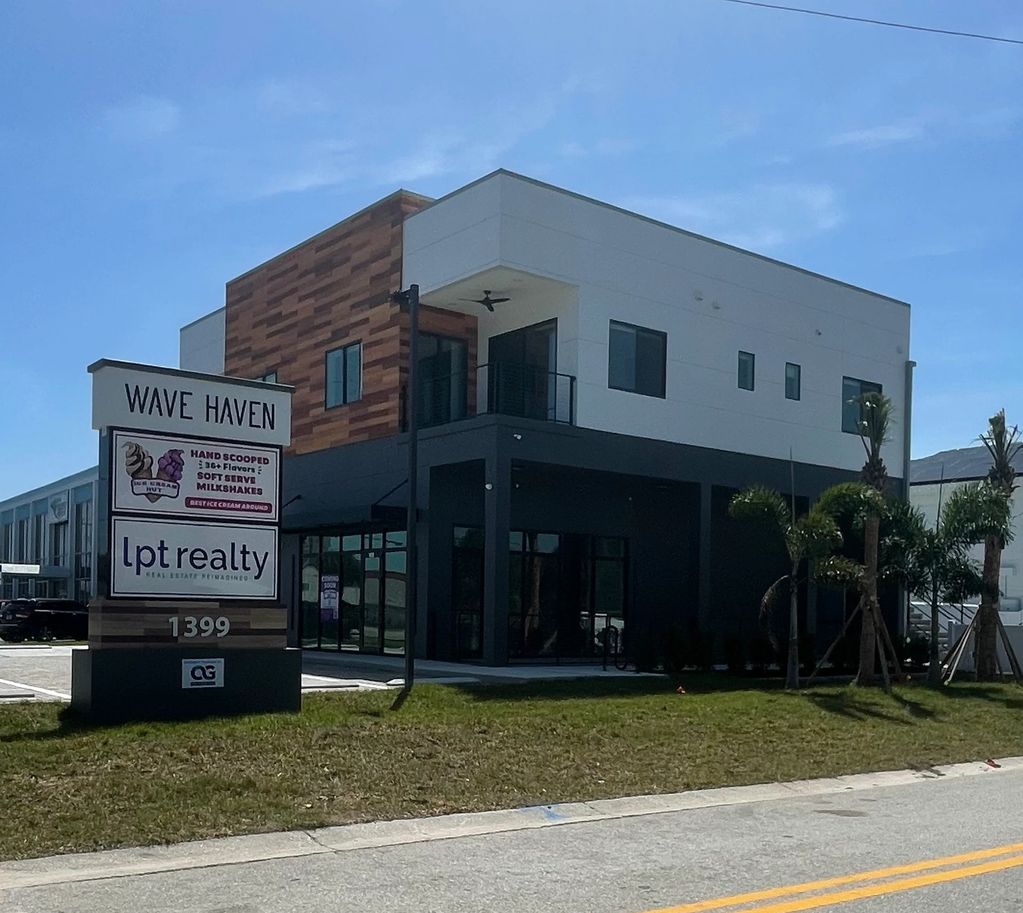 Modern two-story building with signage for Wave Haven and Lpt realty.