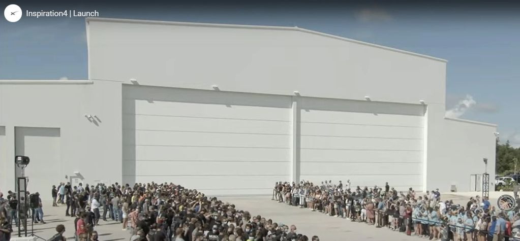 Crowd gathered outside large hangar for Inspiration4 launch.