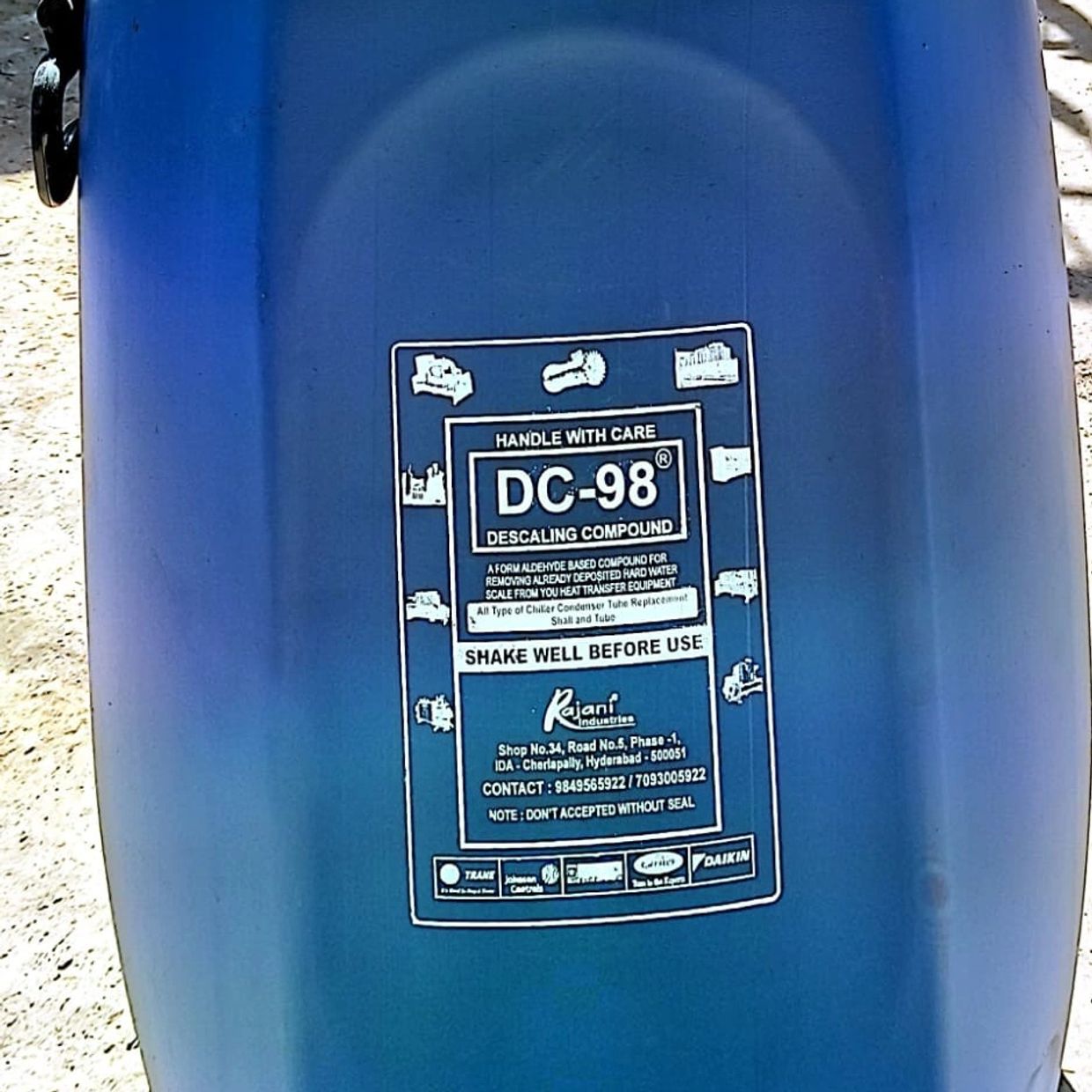 Blue container labeled DC-98 descaling compound for heat transfer equipment.