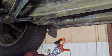 Rusty car undercarriage and a spray gun.