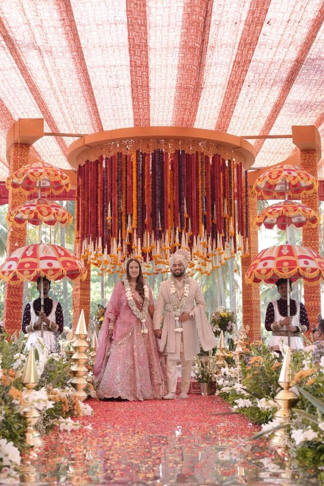 A couple in traditional attire at a beautifully decorated wedding stage.