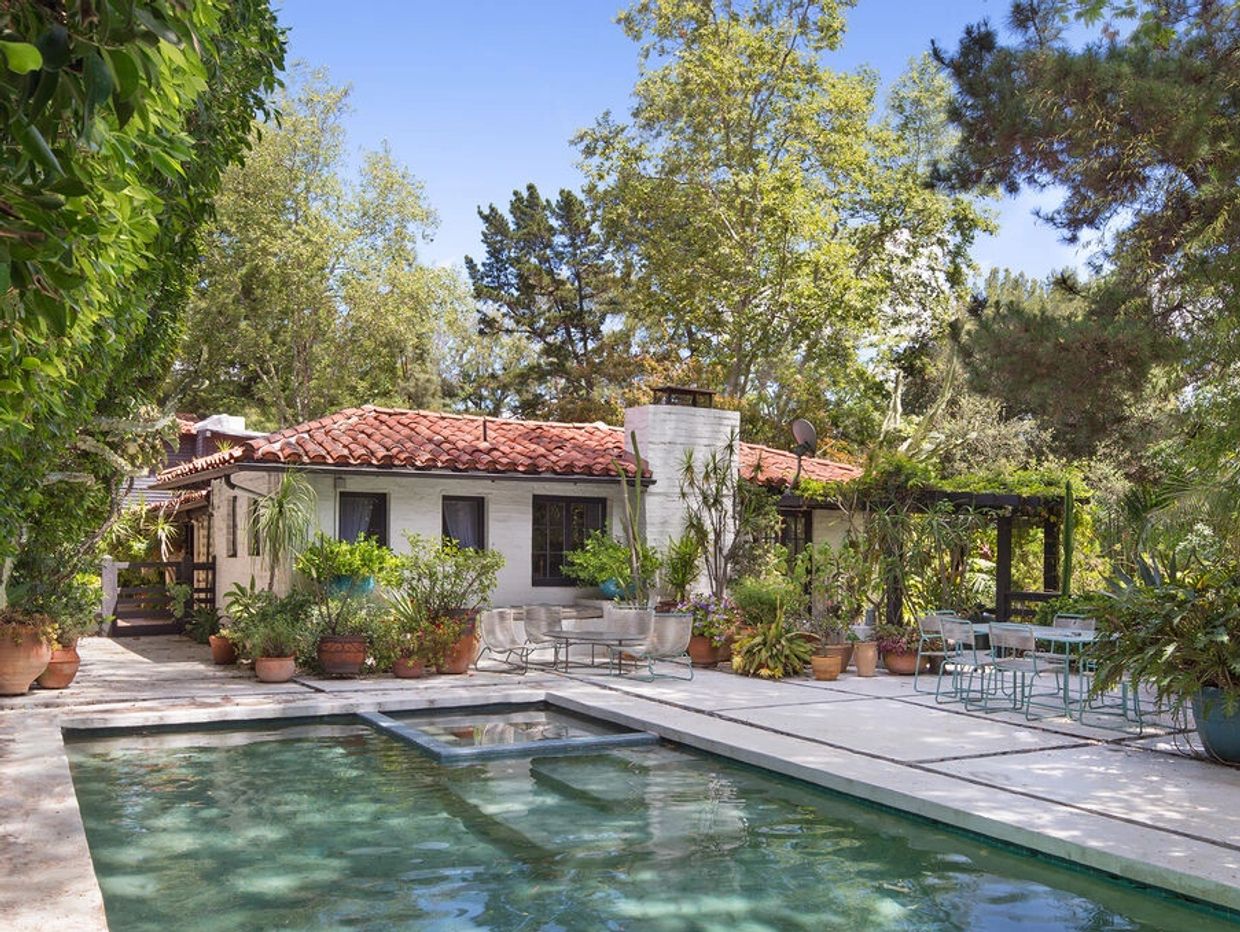 Cozy house with pool surrounded by greenery.