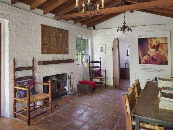 Cozy rustic room with wooden chairs and fireplace.