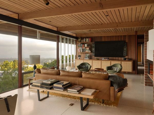 Modern living room with large windows and leather sofa.