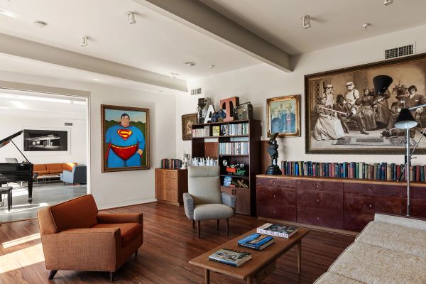 Modern living room with colorful artwork and wooden furniture.