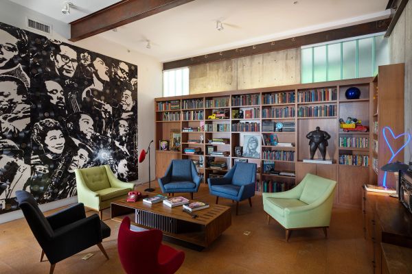 Cozy reading room with colorful chairs and a large mural.