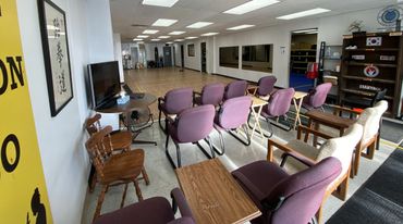 Waiting area with purple chairs and wooden furniture in a clean, well-lit room.