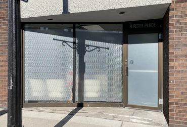Closed storefront with frosted windows and door at 8 Petty Place.
