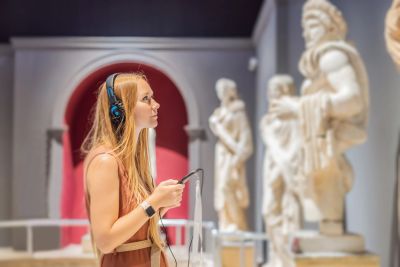 Woman listening to audio guide in museum.