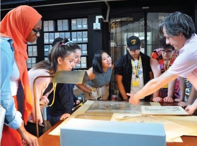 A group attentively studies a display in a museum.
