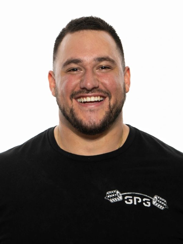 Man with a beard smiling in a black shirt.