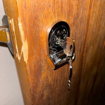 Key inserted in a wooden door lock.