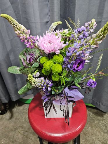 Colorful flower arrangement on a red stool.