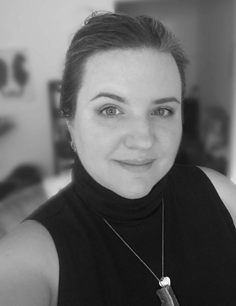 Black and white photo of Dr. Westmoreland, smiling, wearing a sleeveless black turtleneck, hair pull