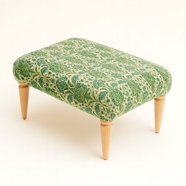Green floral-patterned upholstered ottoman with wooden legs.