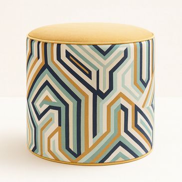 Round ottoman with a colorful geometric patterned fabric and mustard yellow top.