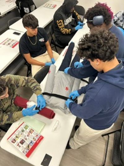 Group practicing medical first aid with a training mannequin.