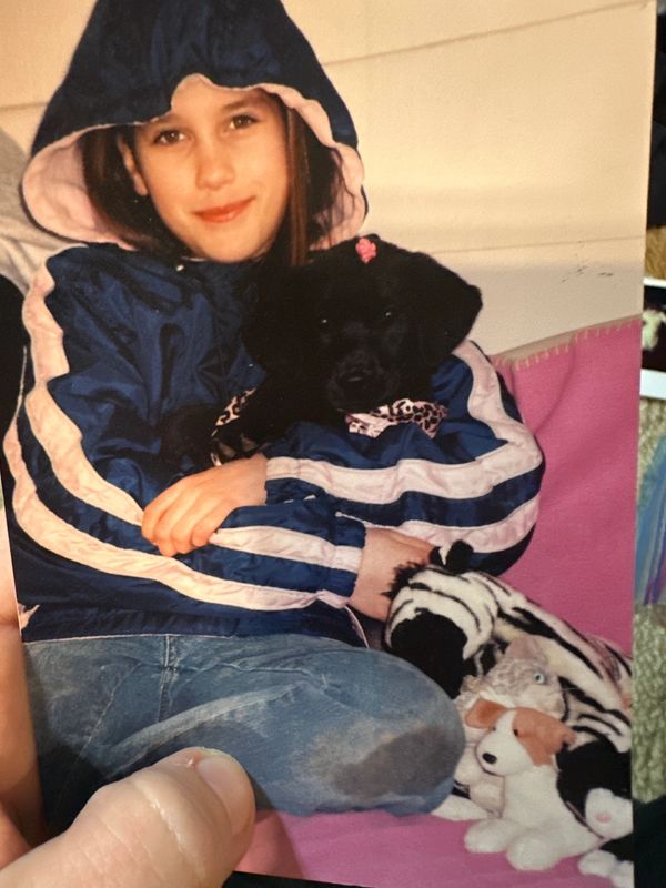 12 year old Kaley holding a black puppy