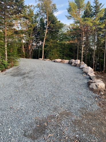 New driveway with granite boulder wall and safety berm