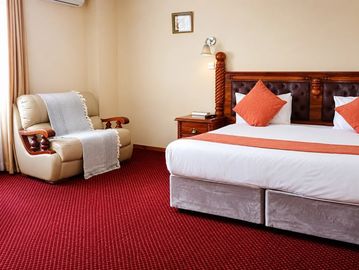 Cozy hotel room with armchair and bed.