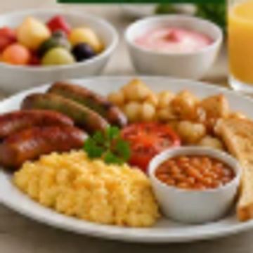 A full breakfast plate with scrambled eggs, sausages, toast, baked beans, and fruit bowl.