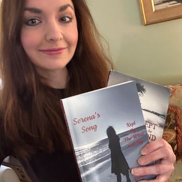 A woman holding two books, smiling at the camera.