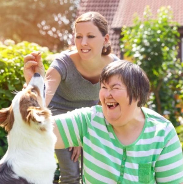 A mentally disabled woman with a support staff and dog.