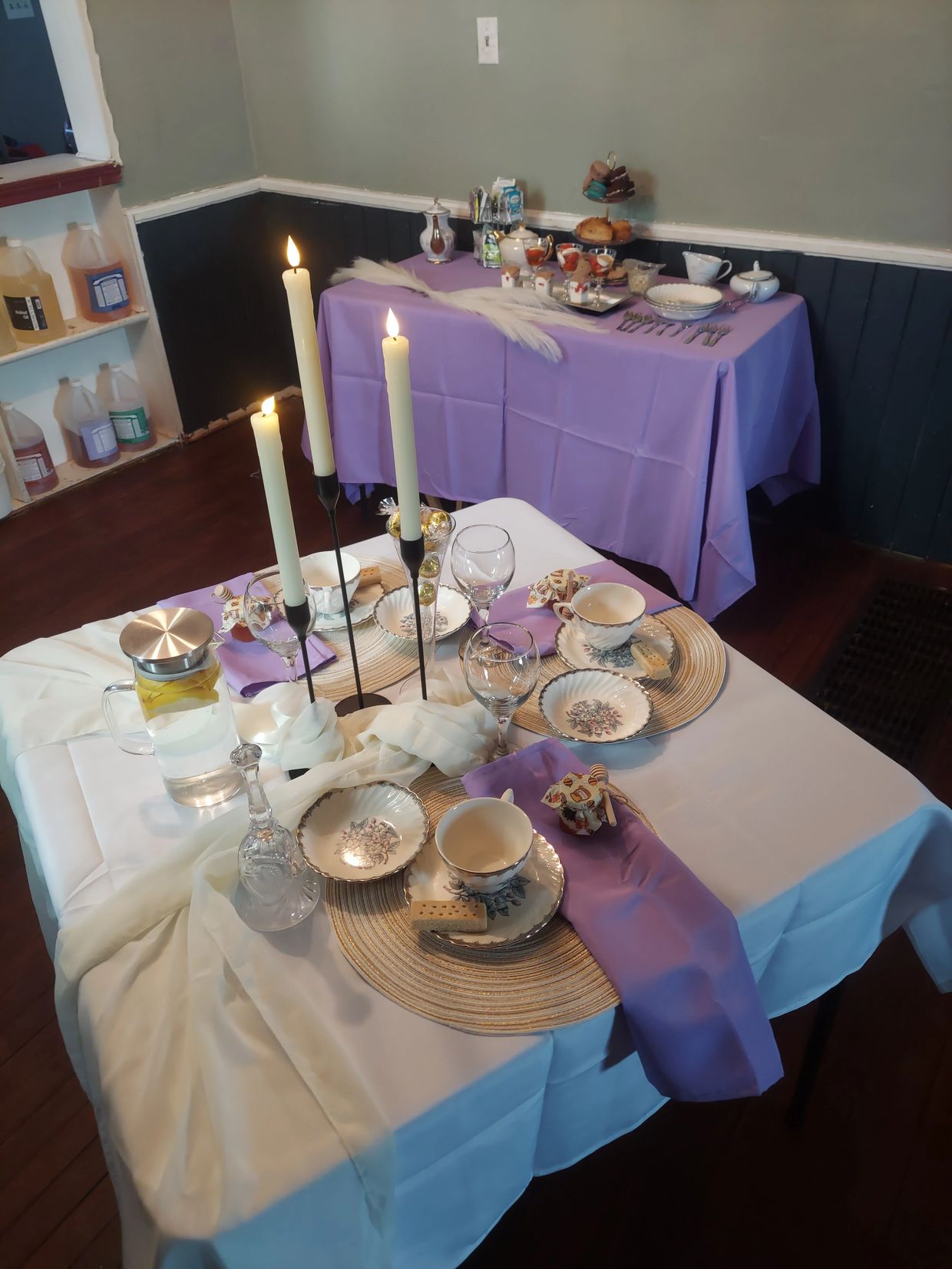 Cream and lavender place settings for tea party. Candle sticks with flameless candles.