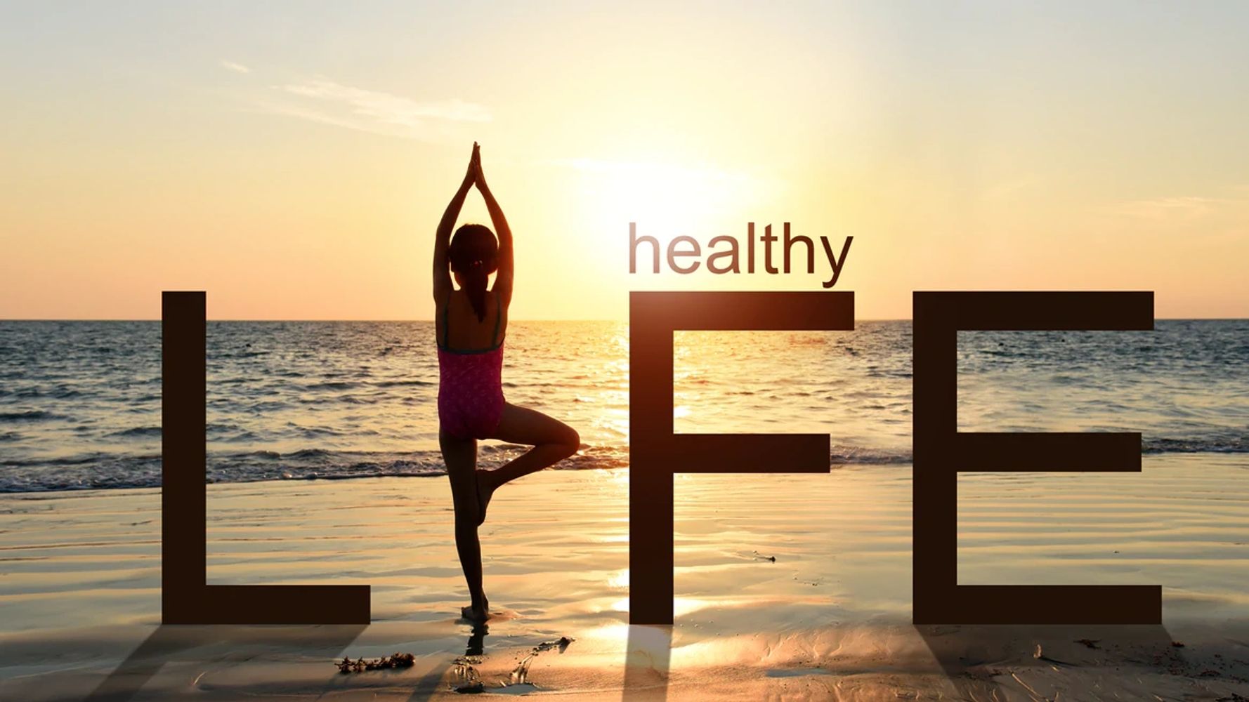 girl standing in a position as the letter 'I' in the word LIFE, facing the sea and a bright sunset 