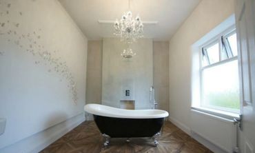 Chandelier and full height glass room divider in new modern bathroom in Southport