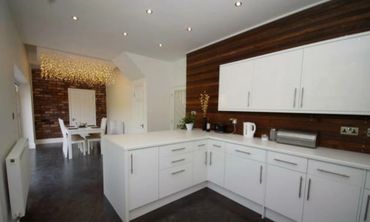 Hanging fairy feature light raft and stained timber paneling in new modern kitchen in Southport