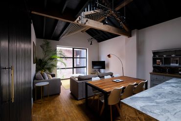 Exposed timber beams and mezzanine floor in converted Victorian warehouse in Southport